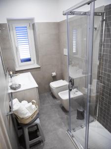 La salle de bains est pourvue d'une douche, de toilettes et d'un lavabo. dans l'établissement Le Casette sul Mare B&B, à Cittadella del Capo