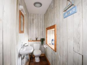 a bathroom with a white toilet and a sink at East Point Lynas Lighthouse Keeper's Cottage in Amlwch +27 photos