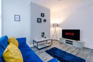 a living room with a blue couch and a tv at Spacious house near City Centre -Sleeps 8 - Parking in Liverpool