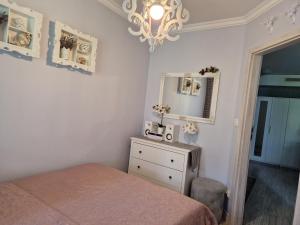 a bedroom with a bed and a mirror and a dresser at Apartament Klaudynka in Jantar