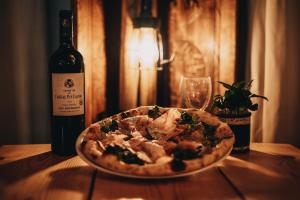 a pizza sitting on a table next to a bottle of wine at Résidence Capfun du Téléphérique, Morzine in Morzine