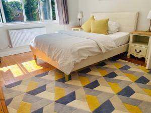 a bedroom with a bed and a yellow and blue rug at Ladram on Haroldslea in Horley