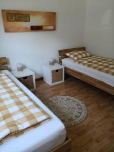 a room with two beds and two tables and a rug at Garten-Wohnung in Eschen
