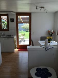 a kitchen with a table and a door to a patio at Garten-Wohnung in Eschen