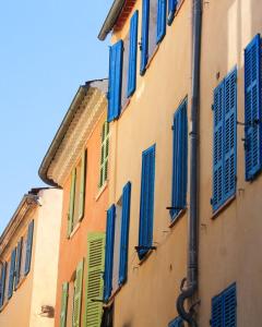 ein Gebäude mit blauen und grünen Rollläden darauf in der Unterkunft Providencia in La Ciotat