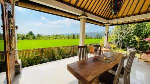 a wooden table and chairs on a patio with a view at Sri Lestari Banyuatis in Munduk