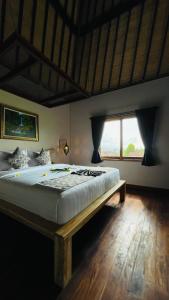 a large bed in a room with a window at Sri Lestari Banyuatis in Munduk