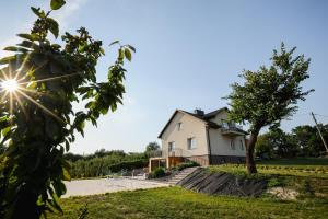 a house on a hill with a tree in the foreground at Dom do wynajęcia z tarasem i ogrodem Rokitek61 in Sandomierz