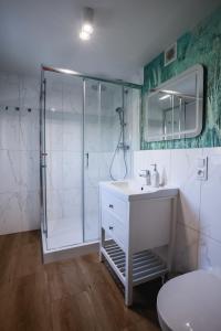 a bathroom with a white sink and a shower at Dom do wynajęcia z tarasem i ogrodem, balia, ognisko in Sandomierz