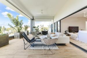 Modern Penthouse - Nautilya BS1 في غراند بايَ: غرفة معيشة مع أريكة بيضاء وكراسي