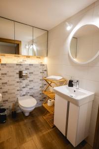 a bathroom with a white sink and a toilet at Dom do wynajęcia z tarasem i ogrodem Rokitek61 in Sandomierz