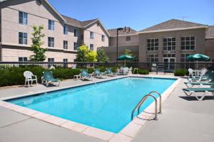 a swimming pool at a hotel with chairs and umbrellas at Homewood Suites by Hilton Colorado Springs-North in Colorado Springs