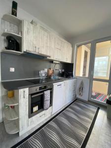 uma cozinha com armários brancos e um lavatório em Gorgeous Two Bedroom Apartment em Silistra