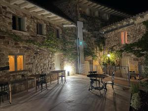 a patio with tables and chairs in front of a stone building at Maison Barón de la Galleta B&B in Quintanilla las Torres