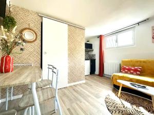 a living room with a table and a yellow couch at Cocon cosy avec un jardin in Talence