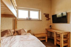 Schlafzimmer mit einem Bett, einem TV und einem Tisch in der Unterkunft Gostilnica Orle - Sleeping in the tower in Škofljica