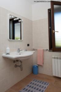 een badkamer met een wastafel en een spiegel bij Agriturismo Serra Maiori in Tramatza