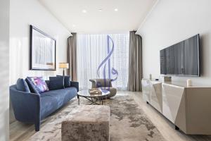 een woonkamer met een blauwe bank en een tafel bij Walaa Homes Luxury 1BR at DAMAC Esclusiva Tower Riyadh-M03 in Riyad