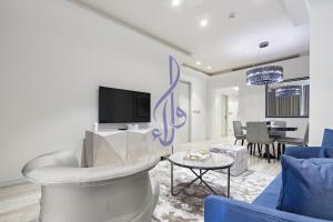 een woonkamer met een bank en een tv bij Walaa Homes Luxury 1BR at DAMAC Esclusiva Tower Riyadh-M03 in Riyad