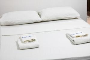 a bed with white sheets and towels on it at Hotel Porto da Lua Belém in Belém