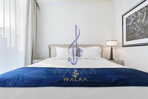 een slaapkamer met een bed met een Walluana-bord erop bij Walaa Homes Luxury 1BR at DAMAC Esclusiva Tower Riyadh-M03 in Riyad