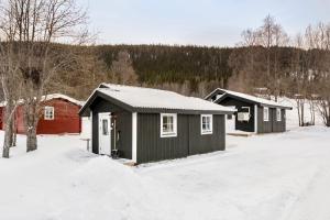 um par de pequenos edifícios na neve em Hyttgårdens stugby i Huså, Åre kommun em Järpen