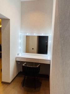 um toucador com um espelho e uma cadeira num quarto em Apartment em Tbilisi