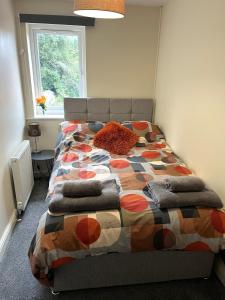 a bed with a colorful comforter in a bedroom at Claygate Place - Modern 2 Bed House with Parking in Nottingham