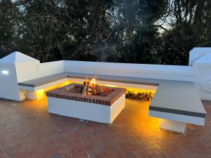 a fire pit sitting on a brick patio with two benches at Sunset Farm Stellenbosch in Stellenbosch