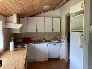 a kitchen with white cabinets and a white refrigerator at Gislinge overnatning in Gislinge