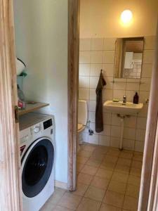 a bathroom with a washing machine and a sink at Gislinge overnatning in Gislinge