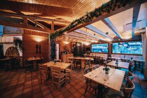 un restaurant avec des tables et des chaises en bois et un grand écran dans l'établissement Résidence Capfun du Téléphérique, Morzine, à Morzine