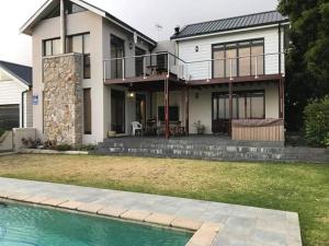 a house with a swimming pool in front of it at Riverside 18 in Hermanus