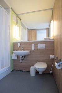 a bathroom with a sink and a toilet at Atlantic Hotel am Floetenkiel in Bremerhaven