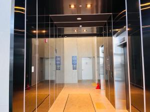 a glass elevator in a building with a hallway at SurfingStay in Yangyang