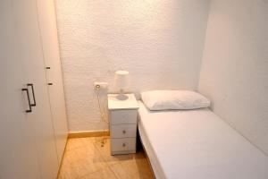 a small room with a bed and a lamp on a night stand at Homenfun Barcelona Sagrada Familia Glories in Barcelona