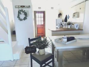 a kitchen with a table and a chair with a plant on it at Beachfront at 22 Settler's Sands in Port Alfred