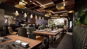 een restaurant met houten tafels, stoelen en verlichting bij Hotel 53° Nord in Brake