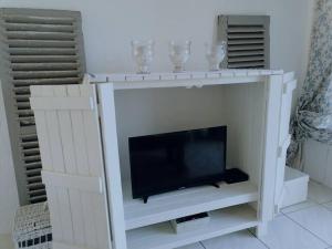 a white entertainment center with a flat screen tv at Beachfront at 22 Settler's Sands in Port Alfred