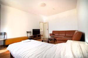 1 dormitorio con cama, sofá y TV en Apartment Centrum Bergisch Gladbach en Bergisch Gladbach