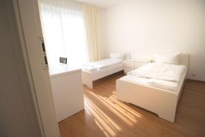 Habitación blanca con cama y ventana en Apartment Centrum Bergisch Gladbach, en Bergisch Gladbach