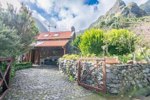 a stone path leading to a house with a stone wall at Guesthouse-TheView in Ribeira Brava