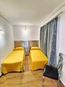 - 2 lits dans une chambre avec des draps jaunes dans l'établissement Mi refugio, à San Fernando