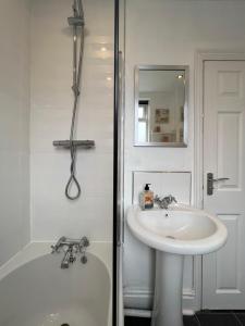 a white bathroom with a sink and a shower at Liverpool Ivy House - 4 Bedrooms in Liverpool