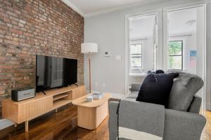 a living room with a couch and a brick wall at Murray Hill 2br w wd nr groceries hospital NYC-1228 in New York
