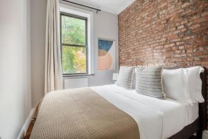 a bedroom with a brick wall and a bed at Murray Hill 2br w wd nr groceries hospital NYC-1228 in New York