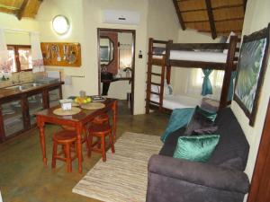 a living room with a couch a table and a bunk bed at Kruger Maroela Lodge in Marloth Park