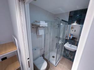 a bathroom with a shower and a toilet and a sink at NATURA ROOMS 