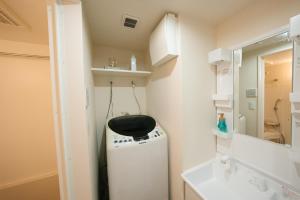 y un baño pequeño con lavadora y secadora. en FL Residence Shinjuku II, en Tokio