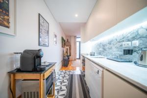 une cuisine avec des placards blancs et un comptoir dans l'établissement JOIVY Modern flat with patio in central Porto, à Porto